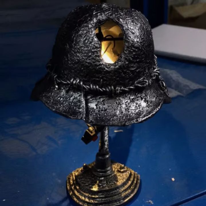 Frontbilde av retro stålhjelm bordlampe. Innebygd LED-flamme gir en varm, inviterende glød.